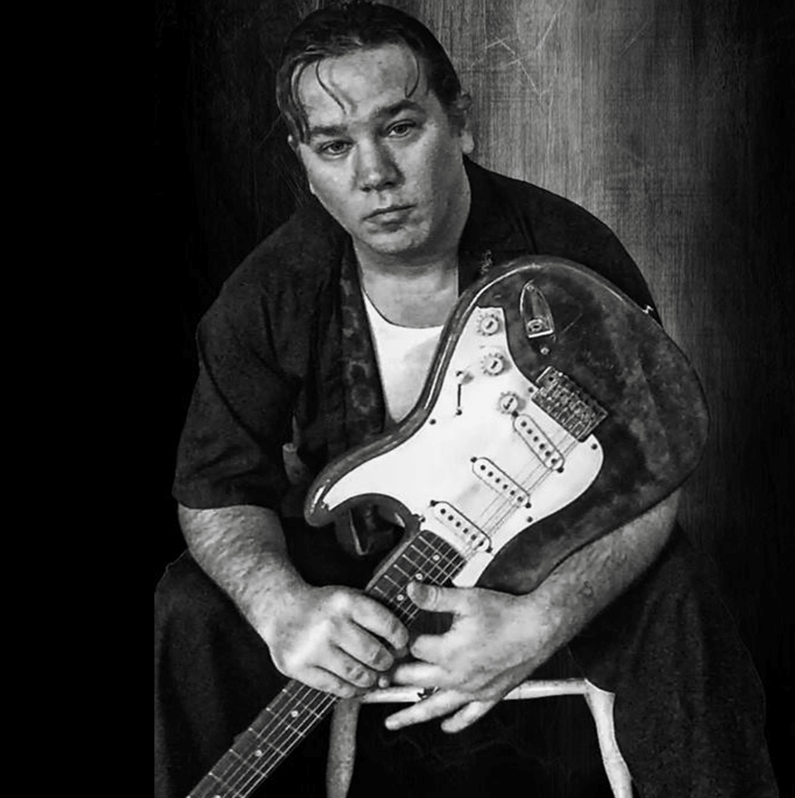 Gordon James seated with Stratocaster